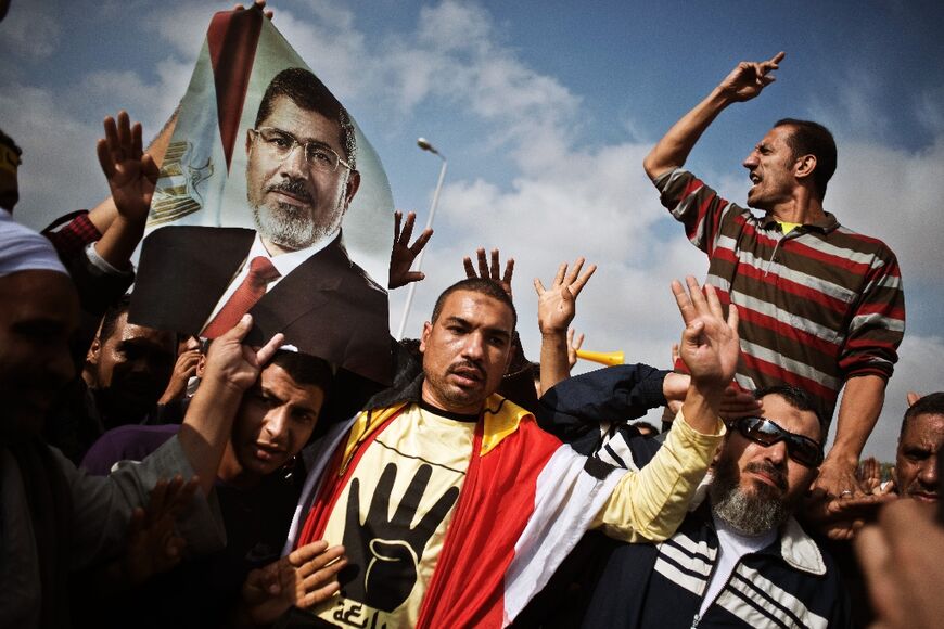Egyptian supporters of the Muslim Brotherhood and of ousted president Mohammed Morsi protest on November 4, 2013 outside the Police Academy in Cairo where Morsi's trial took place