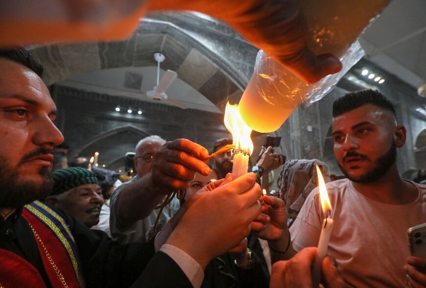 Iraqi Orthodox Christians share the flame of the "Holy Fire" brought from Jerusalem