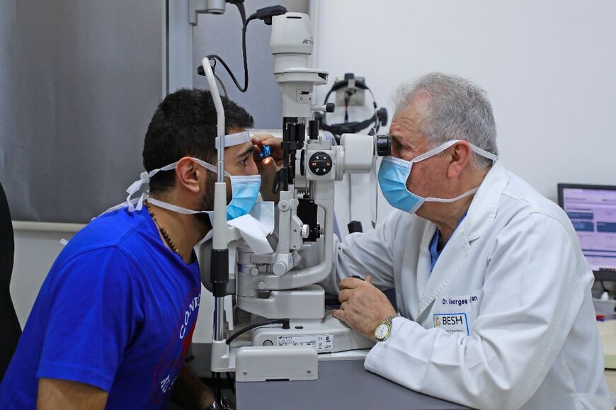 Lebanese ophthalmologist George Cherfan examines a patient's eyes at a branch of the Beirut Eye and ENT Specialist Hospital in the Iraqi capital Baghdad