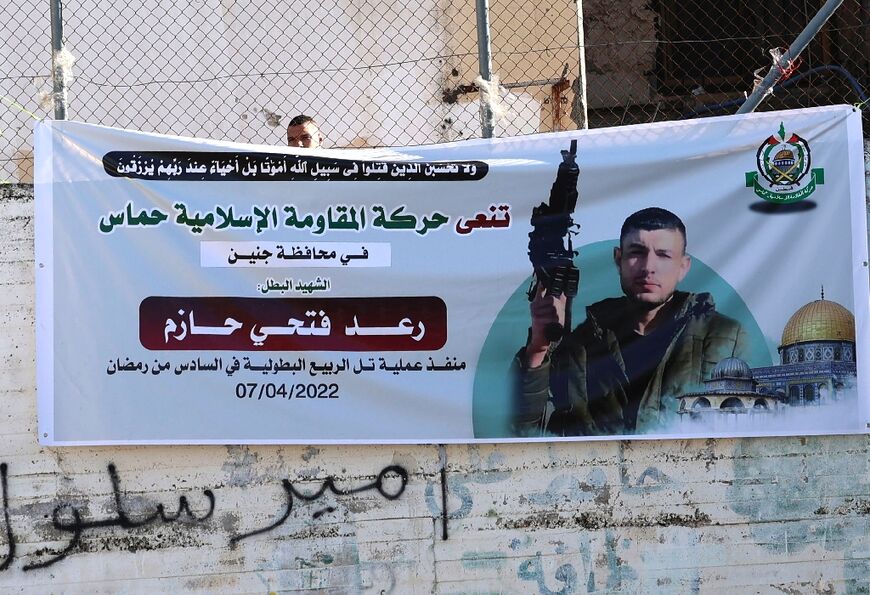 A poster of the 28-year-old Palestinian assailant from Jenin, Raad Hazem, who killed three Israeli civilians and wounded 12 at a Tel Aviv bar before he was shot dead, is displayed in Jenin in the occupied West Bank, on April 12, 2022