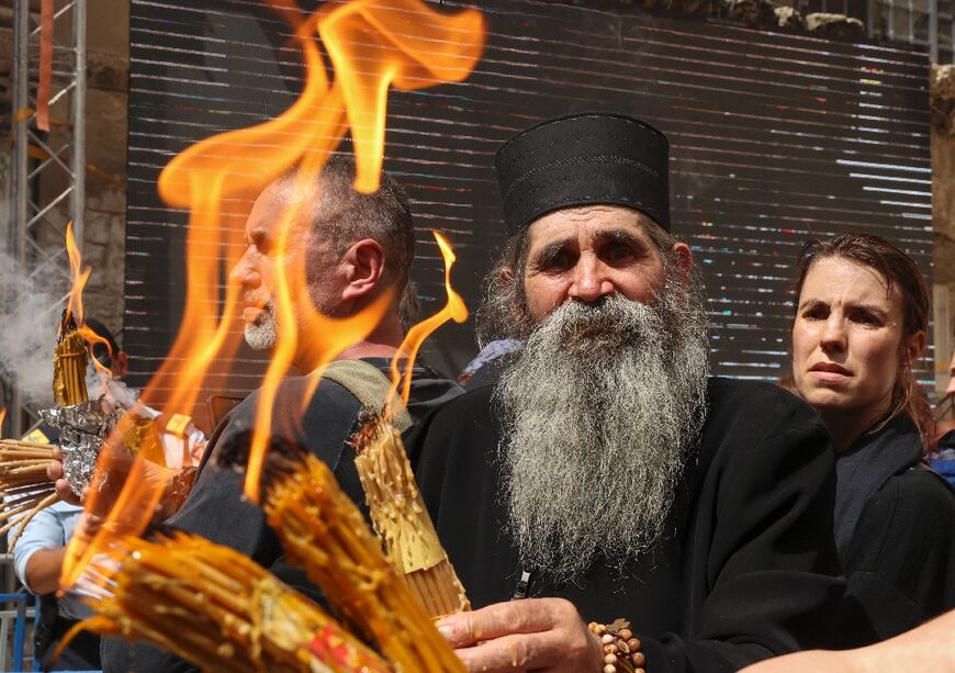An Orthodox priest displays lit candles