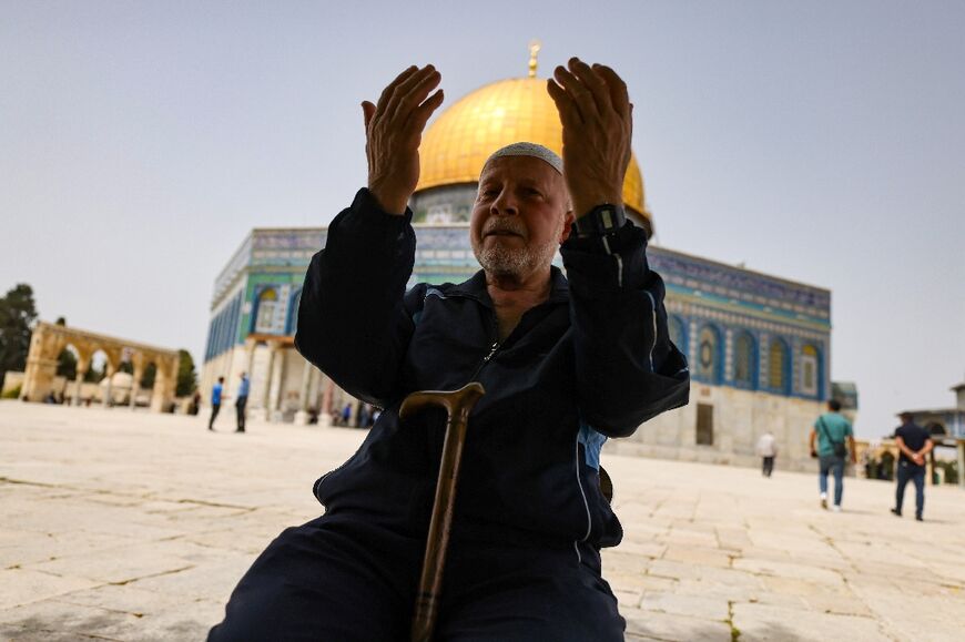 A Palestinian man prays in front of the Dome of Rock mosque at the Al-Aqsa mosque compound in Jerusalem's Old City on April 17