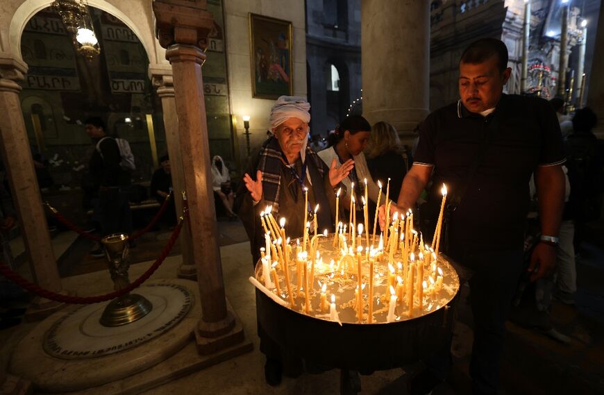 Orthodox Christians light candles on Palm Sunday at the Church of the Holy Sepulchre, in Jerusalem' Old City, on April 17 