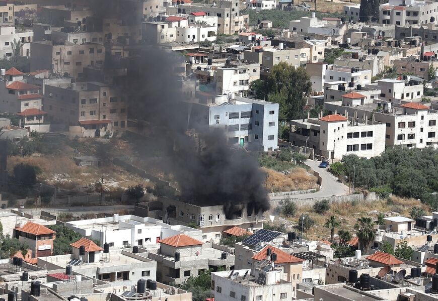 Smoke billows from a building in the Jenin refugee camp on May 13, 2022 during an Israeli military raid