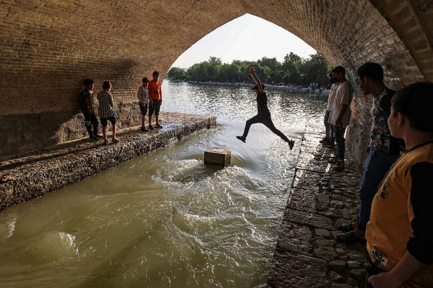 A boy jumps across one of the arches of the 295-metre-long Si-o-Se Pol (33 arches) bridge