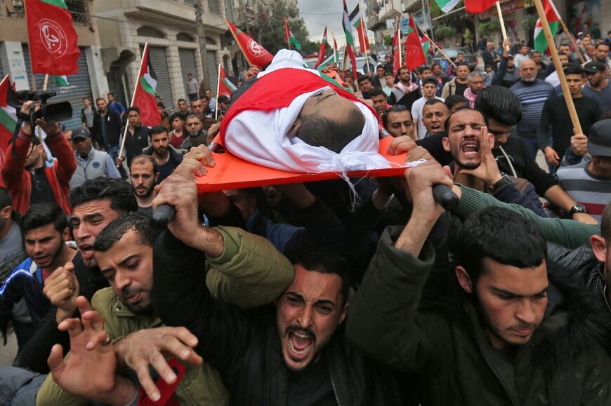 Palestinian mourners carry the body of Palestinian journalist Ahmed Abu Hussein, who was shot by Israeli forces while covering demonstrations on the Gaza border, during his funeral on April 26, 2018