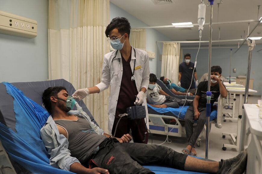 A patient suffering from breathing problems exacerbated by a heavy dust storm receives care wat a hospital in the city of Nasiriyah in Iraq's southern Dhi Qar province on May 16, 2022