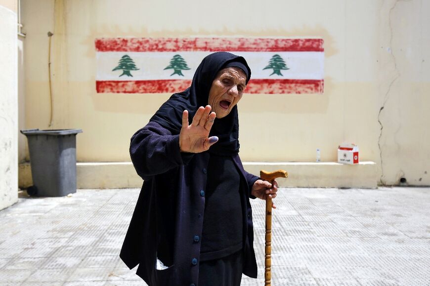 A voter displays her ink-soaked thumb after casting her ballot in the parliamentary election at a polling station in the northern Lebanese city of Tripoli, on May 15, 2022