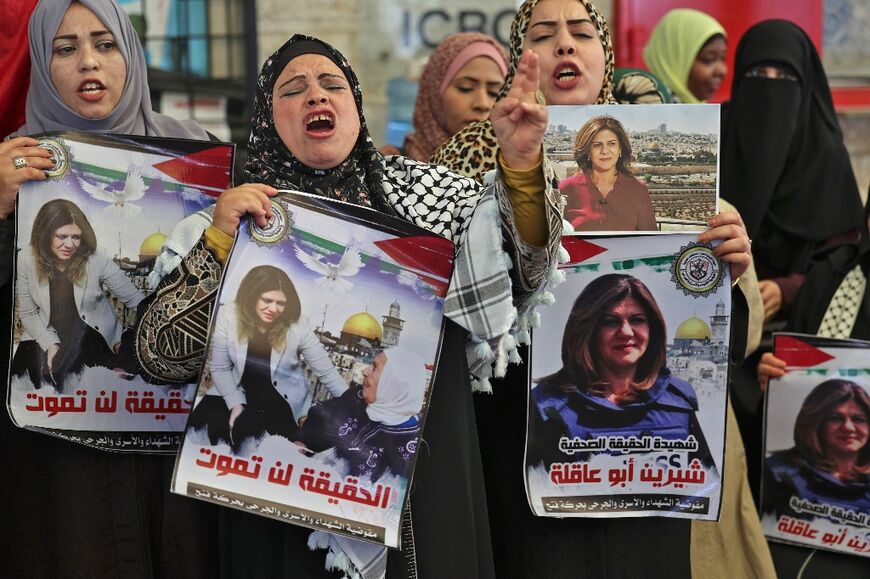 Palestinian women hold pictures of Al Jazeera journalist Shireen Abu Akleh during a demonstration in solidarity with prisoners in Israeli jails, outside the ICRC headquarters in Gaza City on May 16, 2022