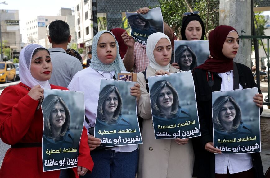 Palestinians hold posters displaying veteran Al Jazeera journalist Shireen Abu Akleh, in the West Bank city of Hebron