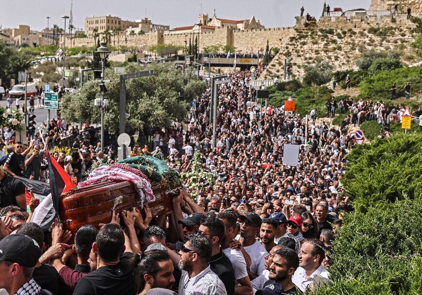 Mourners carry the casket containing Abu Akleh's body from a church toward the cemetery
