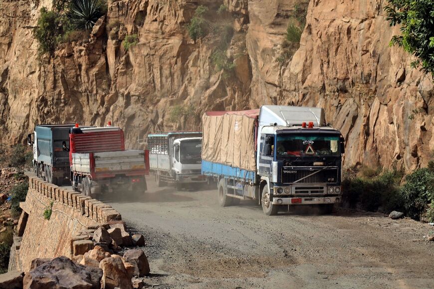 Vehicles travel along a heavily damaged road out of Yemen's long-besieged city of Taez