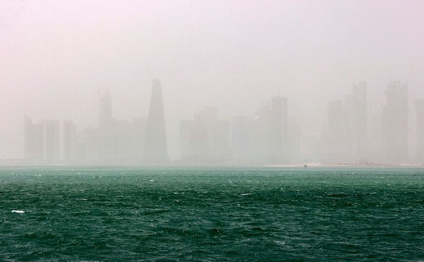 This picture taken on May 17, 2022 shows a view of the haze obscuring the skyline of Qatar's capital Doha during a heavy dust storm