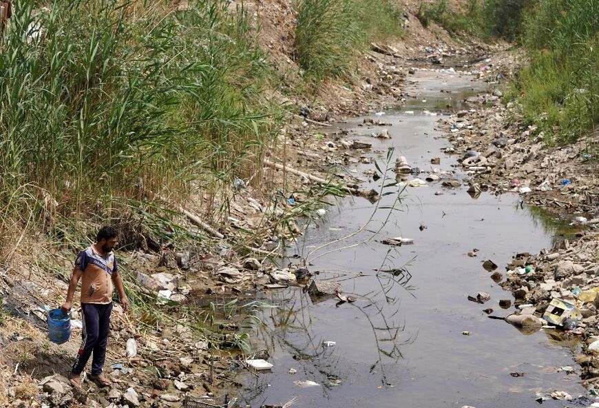 A farmer fetches water from a drying and polluted stream in Najaf province -- Iraq is classified as one of five most vulnerable to climate change effects