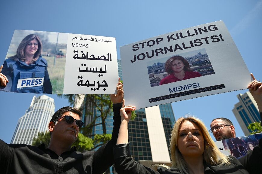 Journalists from different nationalities carry posters bearing Abu Akleh's picture at a gathering to condemn her death, in front of the Israeli consulate in Istanbul on May 12, 2022