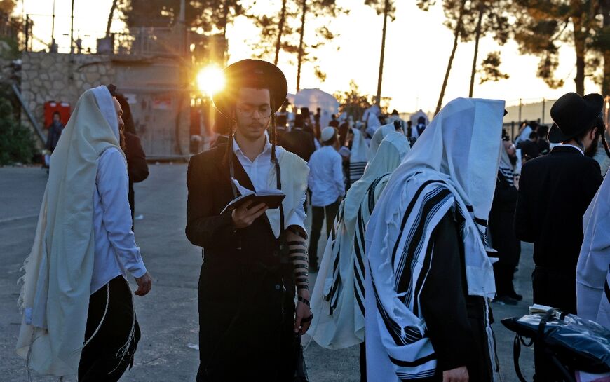 Ultra-Orthodox Jews pray during celebrations at the grave site of Rabbi Shimon Bar Yochai in the early hours of May 19, 2022 at the start of the Lag BaOmer holiday
