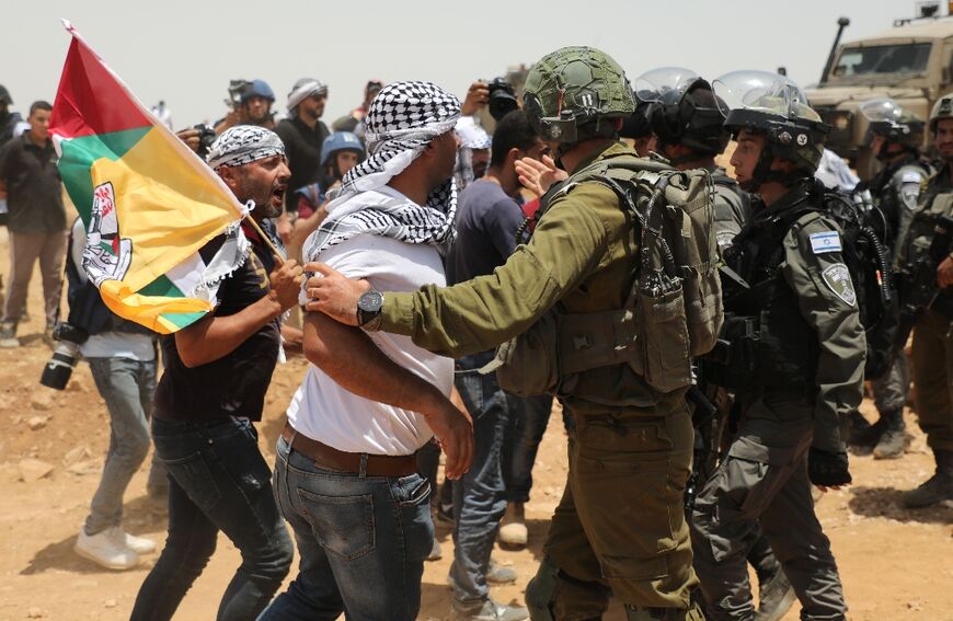 Palestinian demonstrators confront Israeli soldiers on June 17, 2022 in the Masafer Yatta area in the Israeli-occupied West Bank that has been at the centre of a protracted legal battle