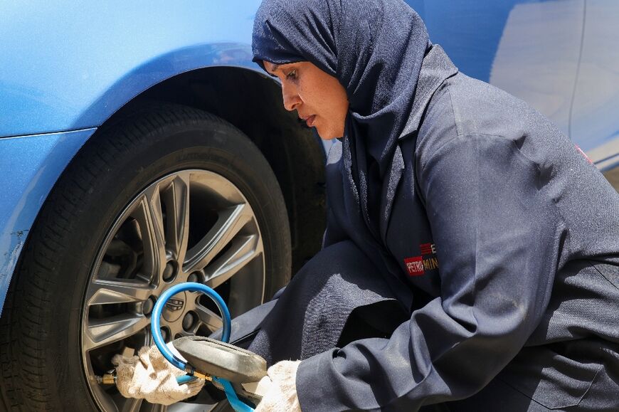 Ola Flimban checks the tyre pressure on a car at a garage in Jeddah