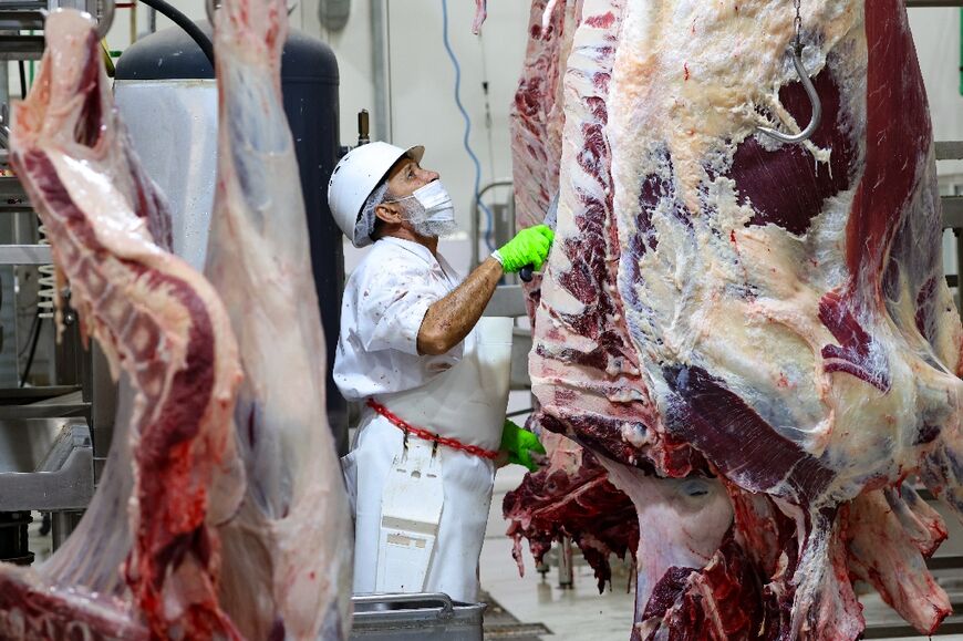 A mask-clad worker at an abattoir in the Gulf emirate of Dubai prepares slaughtered animals for delivery or pick-up