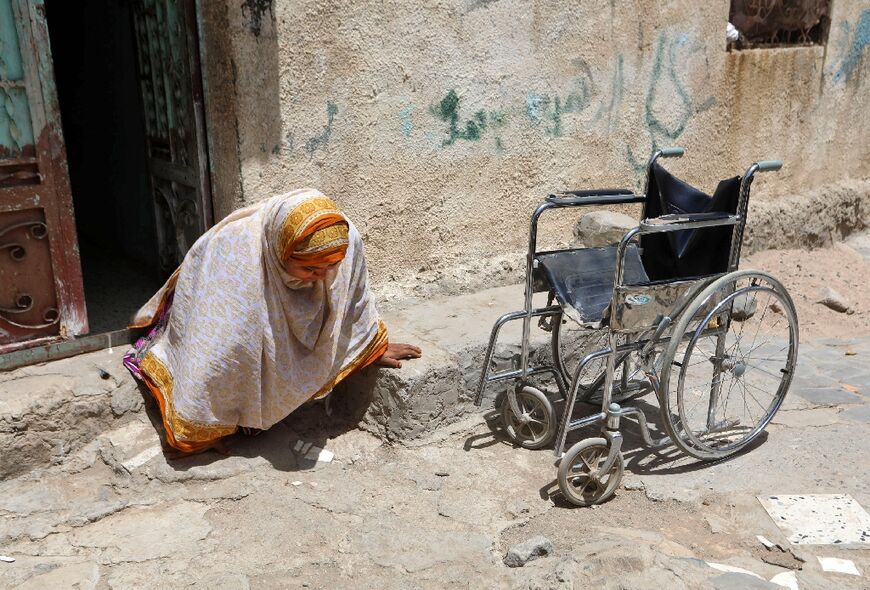 Jamila Qassem Mahyoub, a Yemeni woman whose legs were amputated after stepping on a landmine while herding her sheep in 2017, leaves her house to go to her shop in the  city of Taez on March 20, 2019