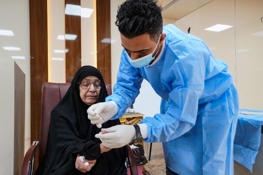 Intissar Mohammed, the sister of a missing person, provides a blood sample