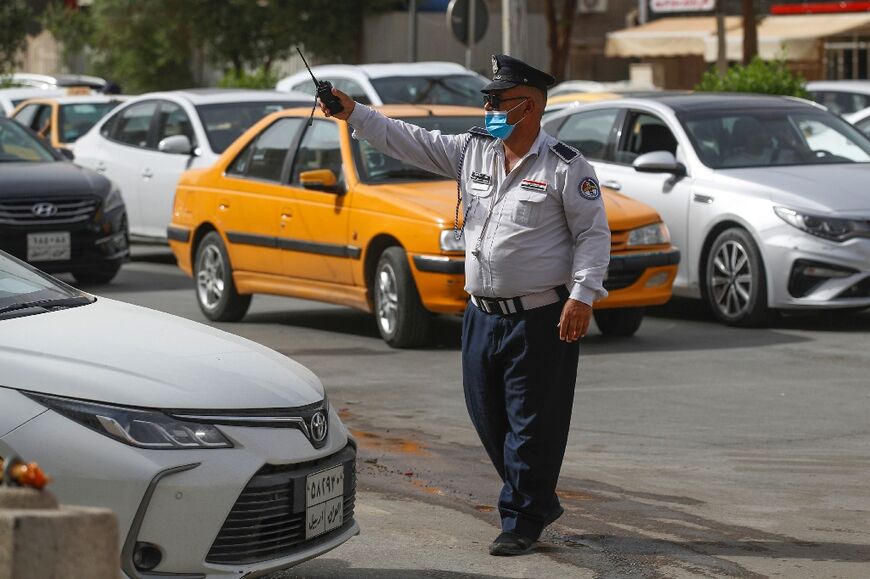 An Iraqi policeman directs traffic in the streets of the capital Baghdad