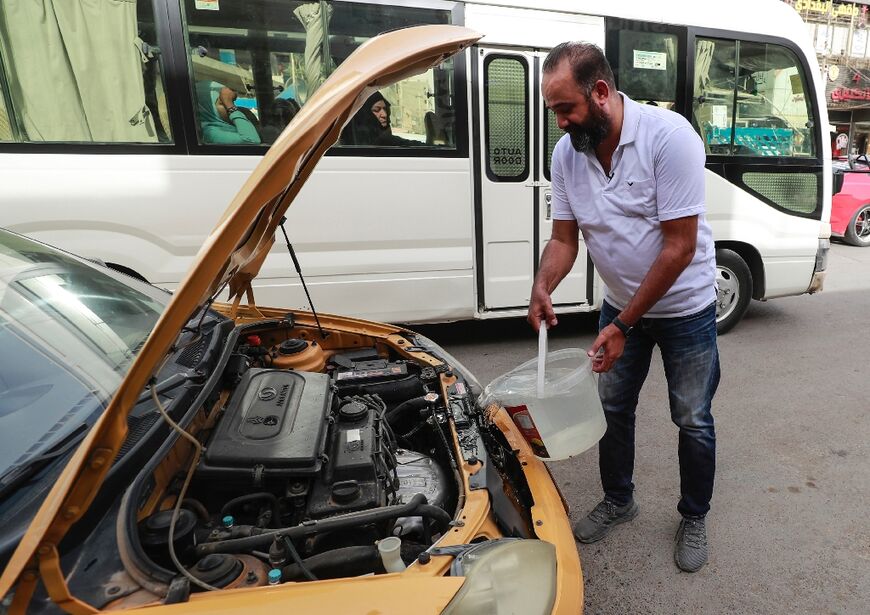 Taxi driver Osama Mohammed tops up his engine with water, as the unrelenting heat of Iraq's Summer descends