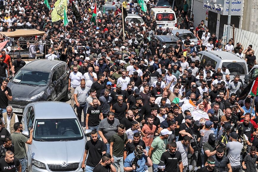 Mourners carry the bodies of three Palestinians killed during an operation by Israeli forces in Jenin, during their funerals in the Jenin camp for Palestinian refugees in the occupied West Bank on June 17, 2022