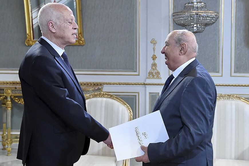 A handout picture provided by the Tunisian presidency on June 20 shows Sadok Belaid, head of Tunisia’s constitution committee, submitting a draft of the new constitution to President Kais Saied
