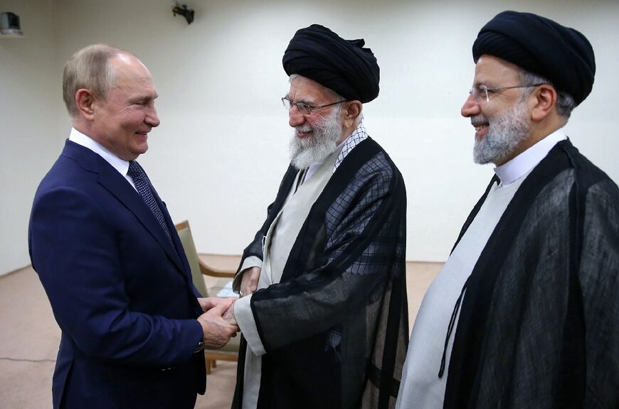 A handout photo provided by the Iranian Supreme Leader Ayatollah Ali Khamenei's office shows him (C) receiving Russian President Vladimir Putin in the presence of his Iranian counterpart Ebrahim Raisi in Tehran, on Tuesday