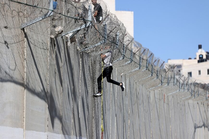 A youth descends Israel's controversial separation barrier into East Jerusalem