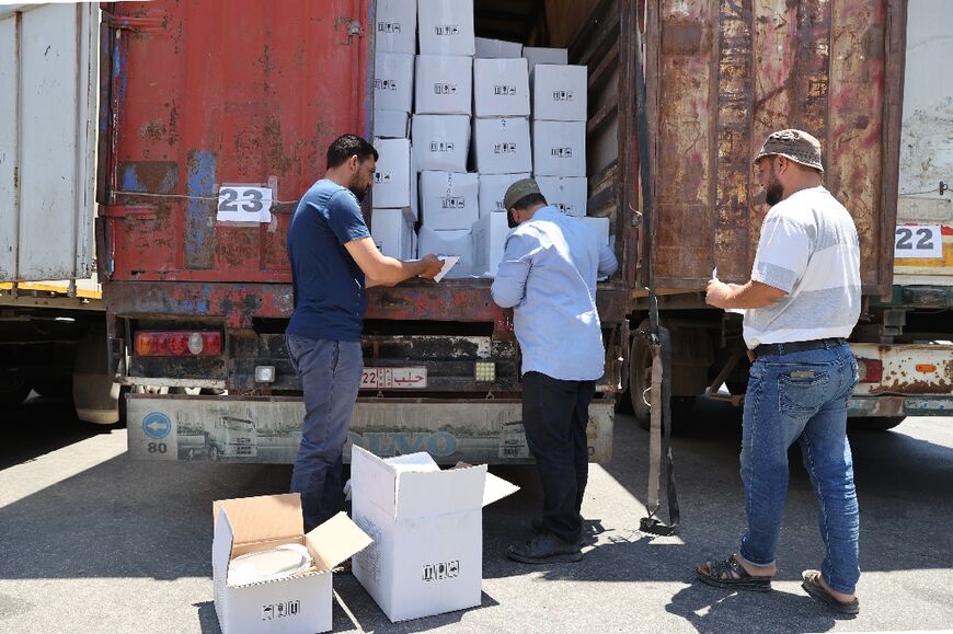 Customs officers inspect a convoy of humanitarian aid after it crossed into Syria from Turkey through the Bab al-Hawa border crossing on July 8, 2022. Silence has prevailed over the border area since a final aid convoy crossed over on Friday