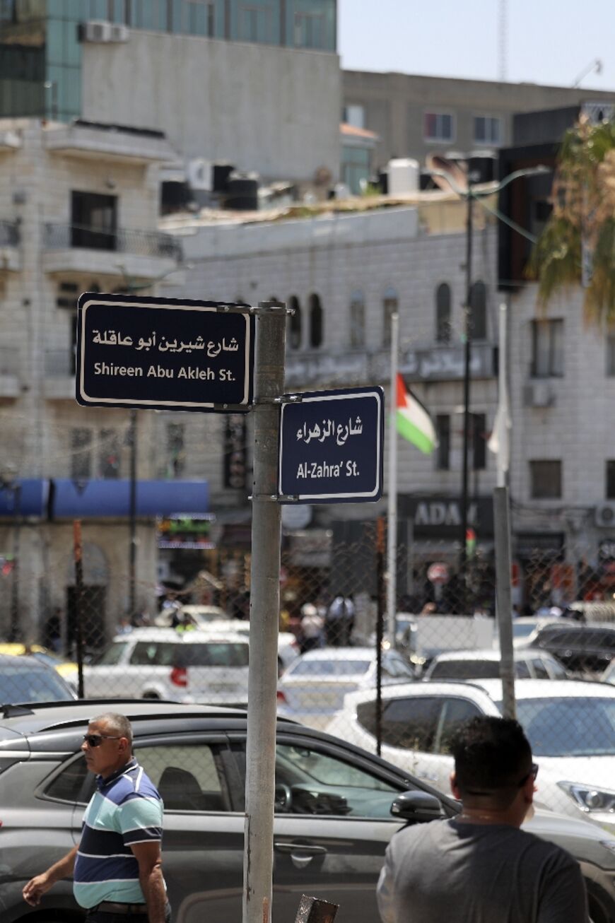 People walk past a newly erected street sign in the Palestinian city of Ramallah in the occupied West Bank in June 2022 bearing the name of slain veteran Al Jazeera correspondent Shireen Abu Akleh