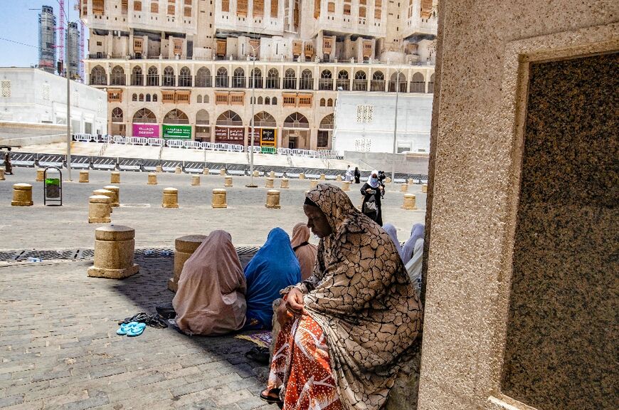 Women rest in the shade in the Saudi holy city of Mecca, where temperatures have reached 42 degrees Celsius