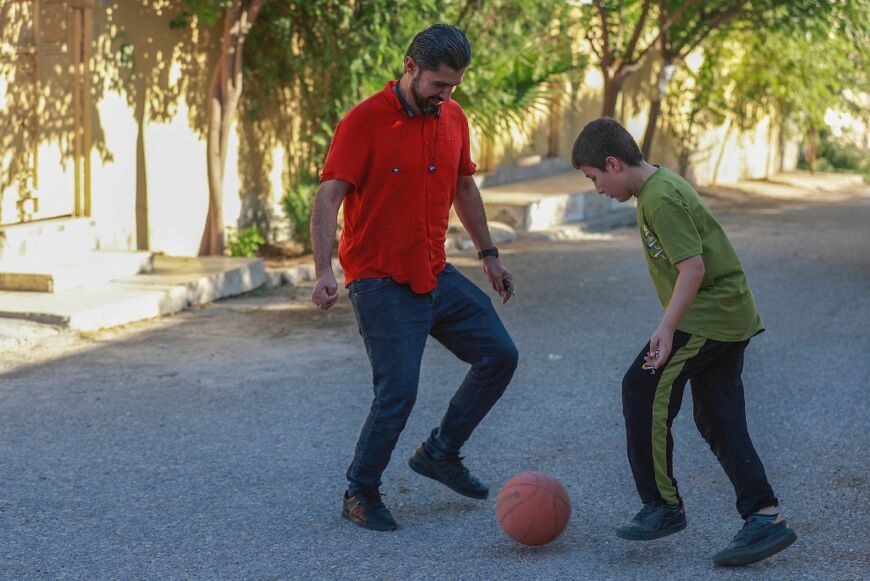 Haresh Talib plays football with his son outside their home in Iraq's northeastern city of Sulaimaniyah