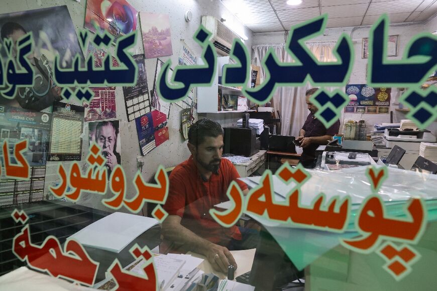 Talib works at his desk at a printing house in Iraq's northeastern city of Sulaimaniyah