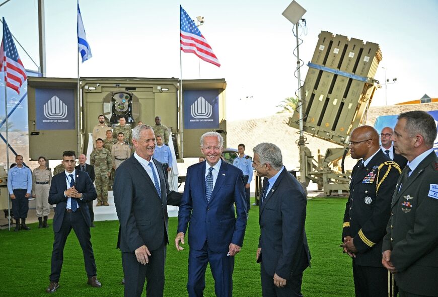 Biden smiles as he poses in front of an Iron Beam and an Iron Dome air defence system (R) with Israeli Defence Minister Benny Gantz
