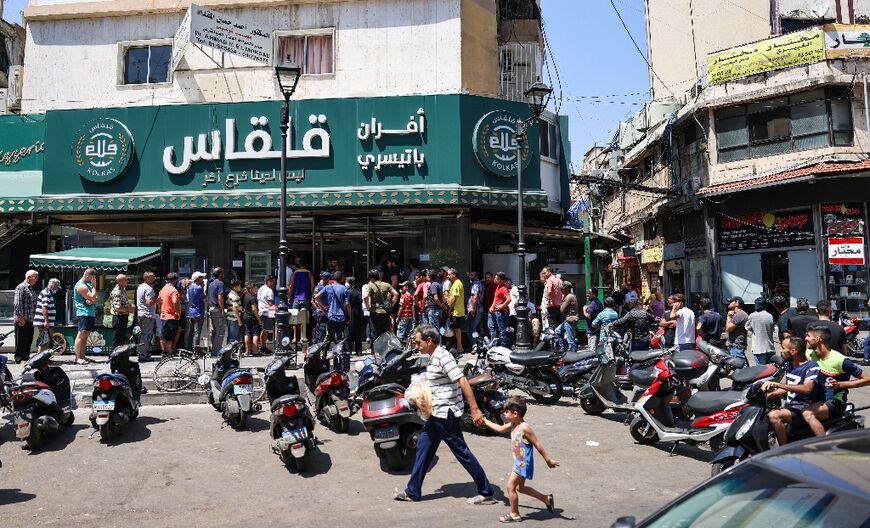 A long queue stretches down the street from a Beirut bakery. In some parts of Lebanon, there have been reports of fights or even gunfire outside bakeries as anger boils over