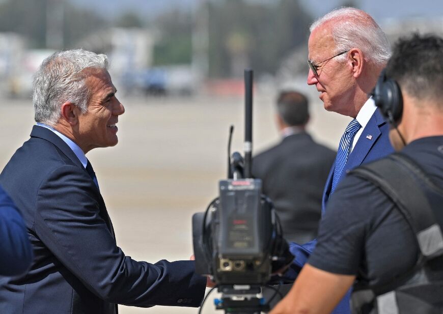 Israel's caretaker prime minister Yair Lapid, on the left,  greets US President Joe Biden at Ben Gurion Airport 