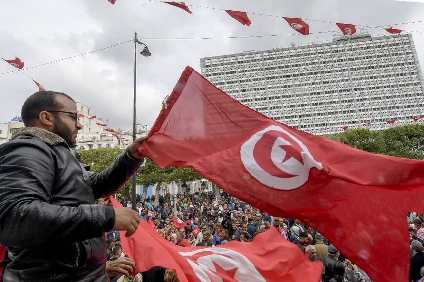 Tunisian demonstrators chant slogans and wave their country's national flag in support of President Kais Saied, in the capital Tunis, on May 8