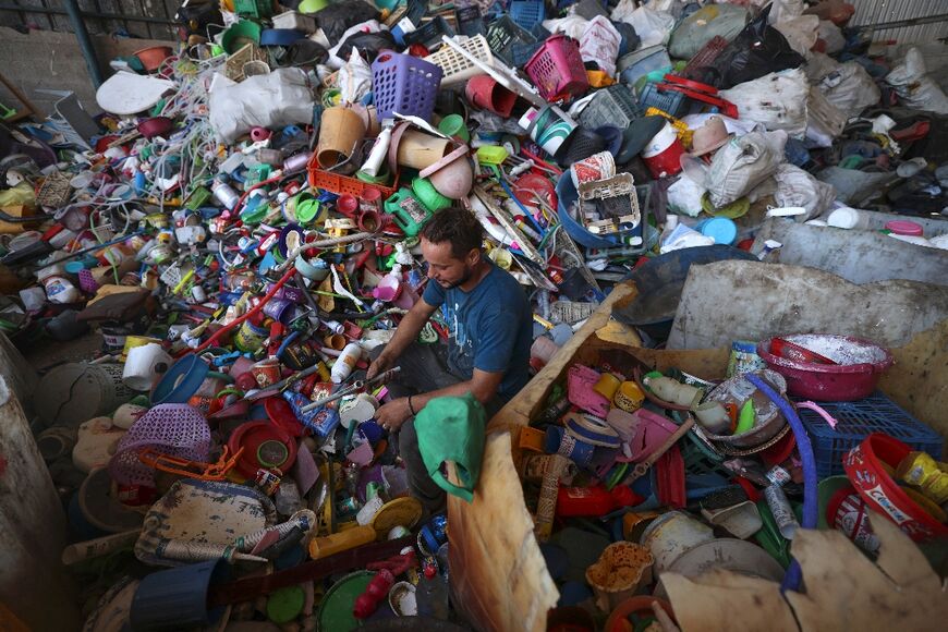 At a sorting facility near the distilling site, men comb through towering heaps of baskets, bowls, buckets and other plastic waste