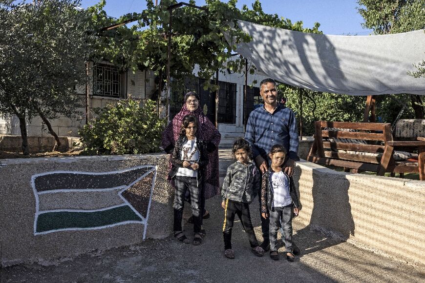 Saadat Sabri Gharib (R) and his family, in front of his house, an enclave circled by the Jewish settlement of Givon Hahadasha