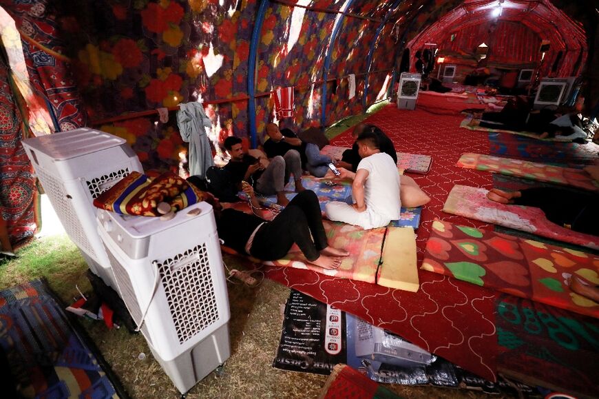 Sadr supporters rest in an air-conditioned tent