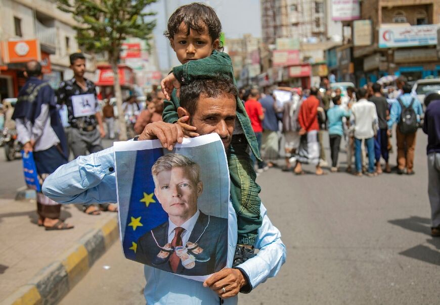 Yemeni demonstrators hold a portrait of UN special envoy Hans Grundberg during a protest demanding the end of a blockade of city of Taez imposed by Yemen's Huthi rebel, seen here on July 26