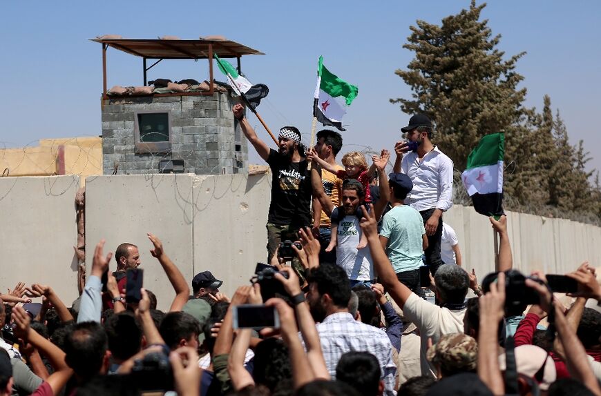 Syrians rally outside a Turkish army position in the opposition-held village of Mastuma 