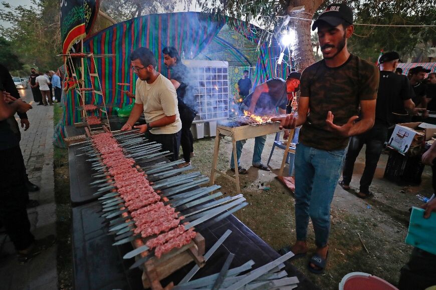 In the rival camp, volunteers prepare skewers of meat for supporters of the pro-Iran Coordination Framework alliance