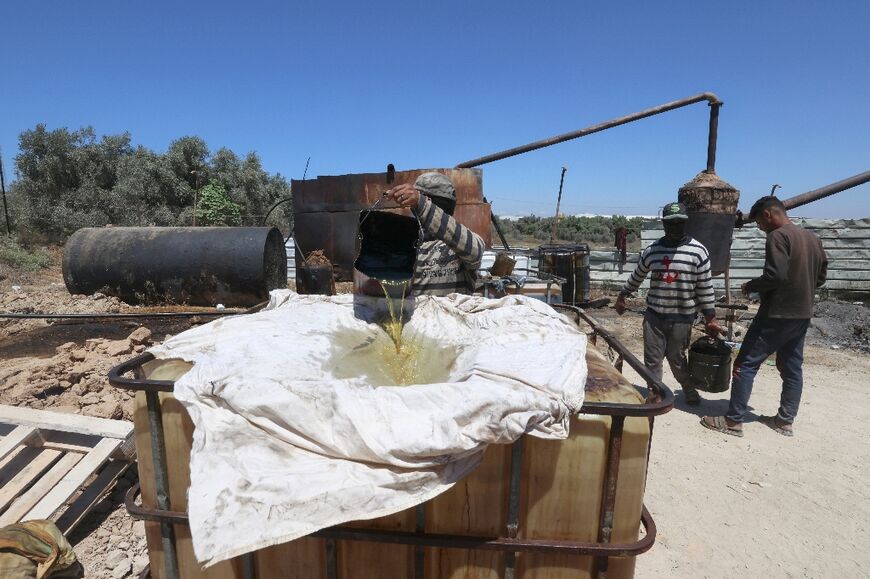 A Palestinian worker pours out processed fuel from recycled plastic: petrol delivered from Israel shot up in price after Russia's invasion of Ukraine sent global fuel prices spiking