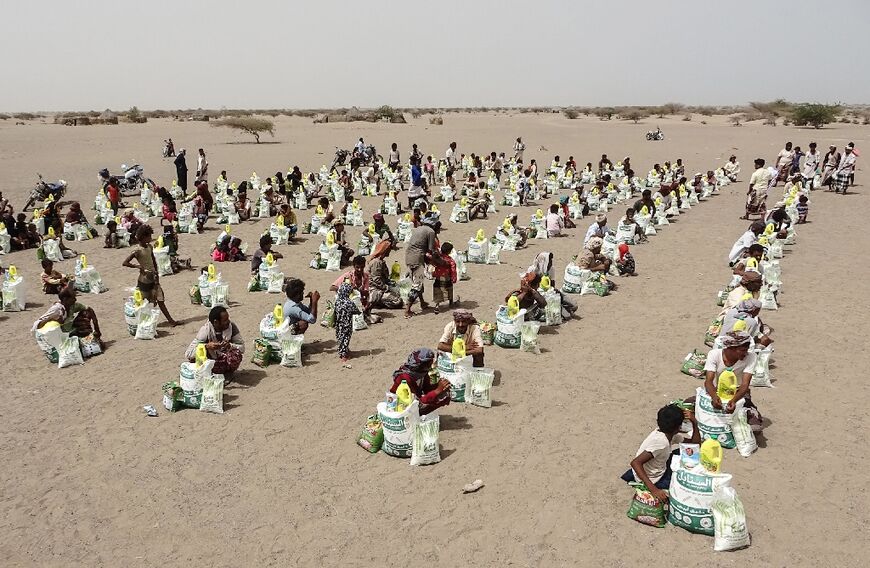 More than two thirds of Yemen's 30 million people need humanitarian aid, acccording to the United Nations: here food aid is handed out in Hodeida province in July