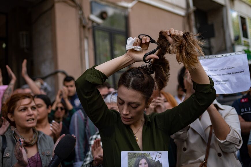 Nasibe Samsaei, an Iranian woman living in Turkey, cuts her ponytail off during a protest outside the Iranian consulate in Istanbul