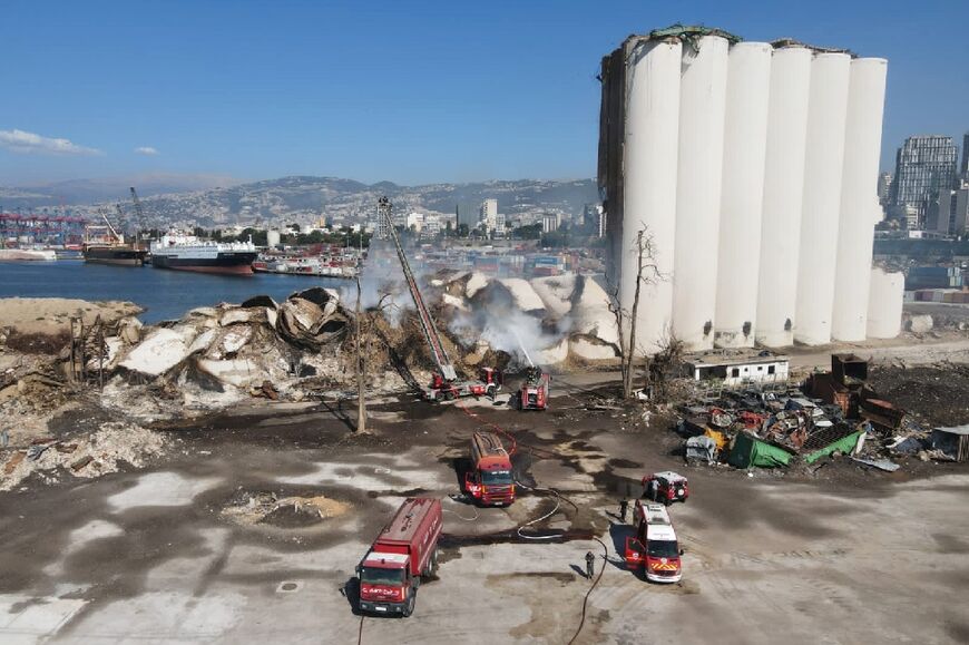 Firefighters douse the smoldering rubble of collapsed grain silos at Beirut port which were hit by the huge explosion in August 2020